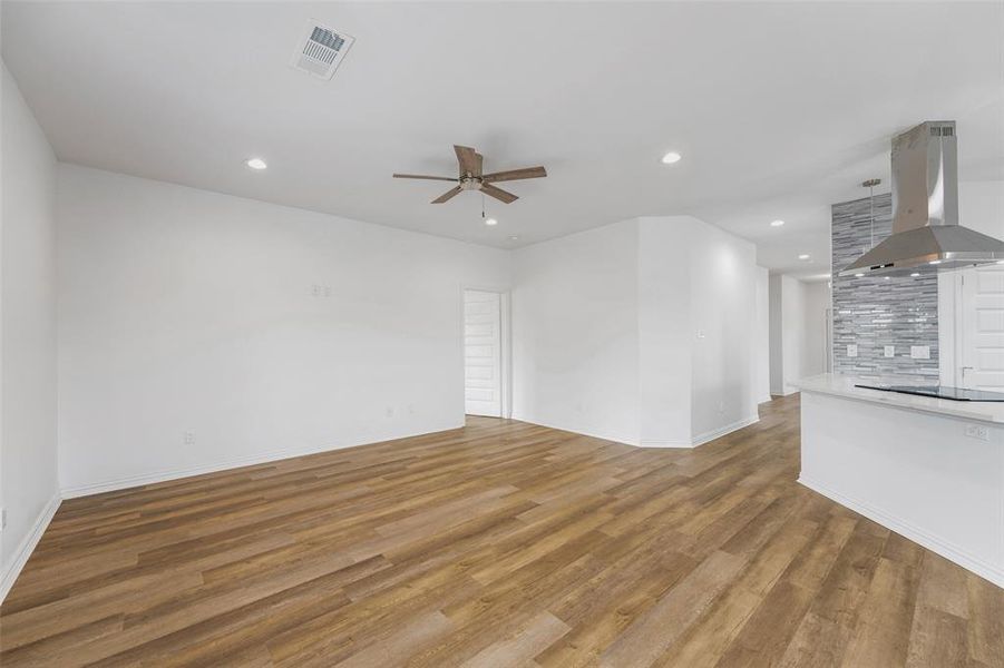 Open-concept living space featuring wood-finish flooring, recessed lighting, and a ceiling fan