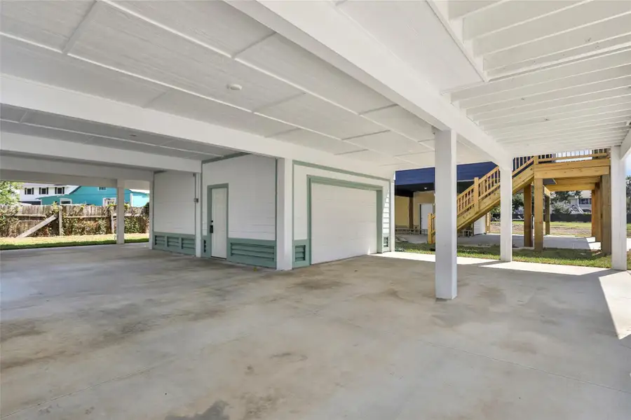 Spacious covered parking area and storage area.