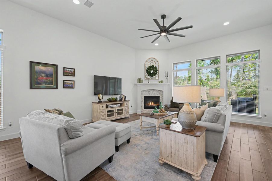 The family room has recessed lights, a large eight blade ceiling fan, and a corner fireplace. The fireplace was an add on during construction and has marble tile surround set in a herringbone pattern. The wood mantel was an upgrade to this fireplace with gas logs. The family room has recessed lights, a large eight blade ceiling fan, and a corner fireplace. The fireplace was an add on during construction and has marble tile surround set in a herringbone pattern. The wood mantel was an upgrade to this fireplace with gas logs.