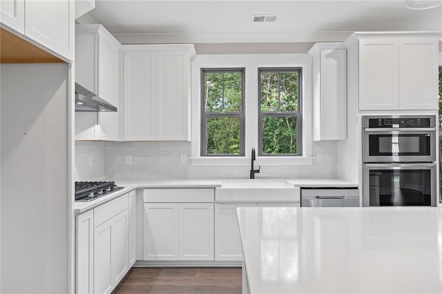 This bright kitchen features sleek appliances, amp