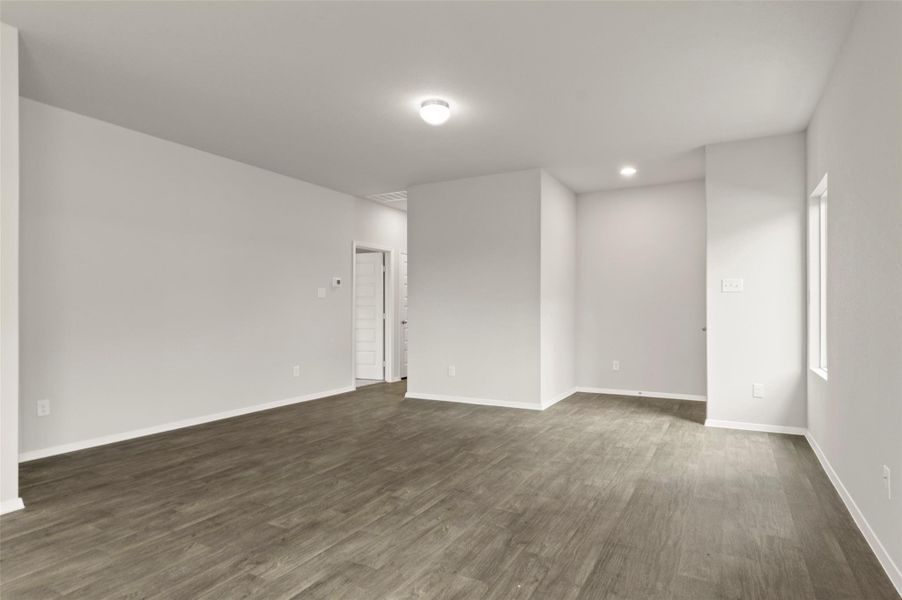 Empty room featuring dark wood-type flooring and recessed lighting