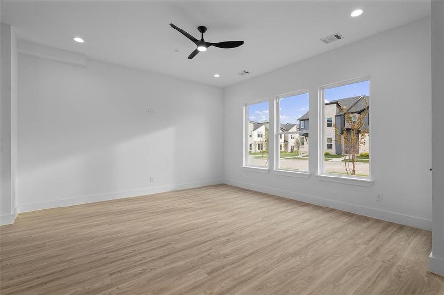 Unfurnished room featuring light wood-style floors, recessed lighting, a ceiling fan, and a residential view Unfurnished room featuring light wood-style floors, recessed lighting, a ceiling fan, and a residential view