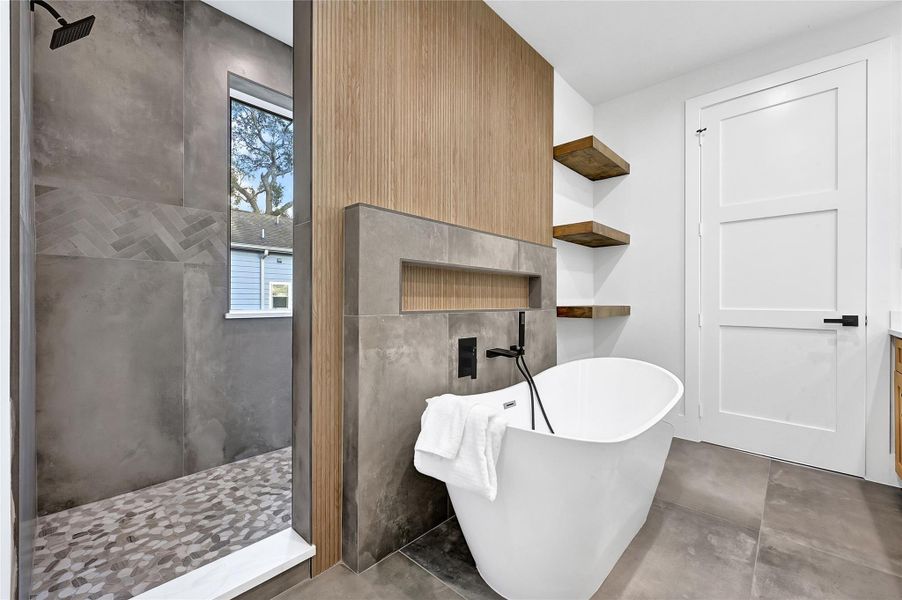 Spa-inspired primary bathroom with freestanding soaking tub and walk-in shower