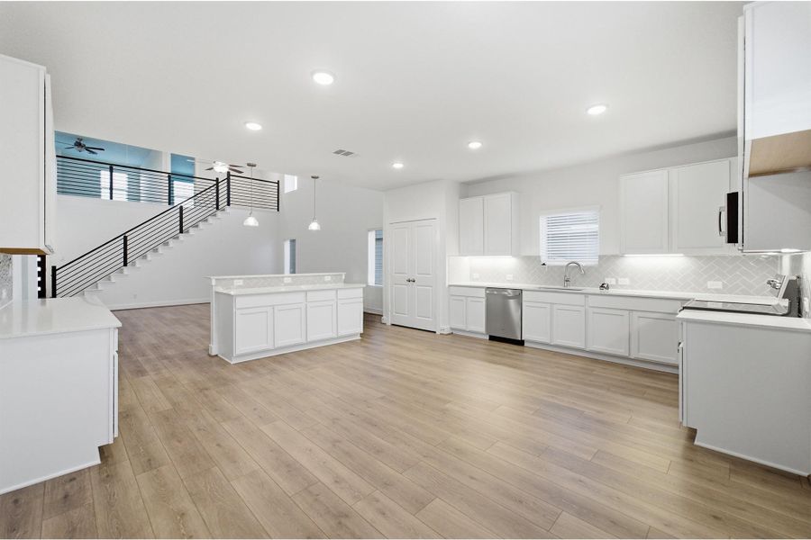 Kitchen with white cabinetry, decorative backsplash, a center island, stainless steel dishwasher, and black electric range oven