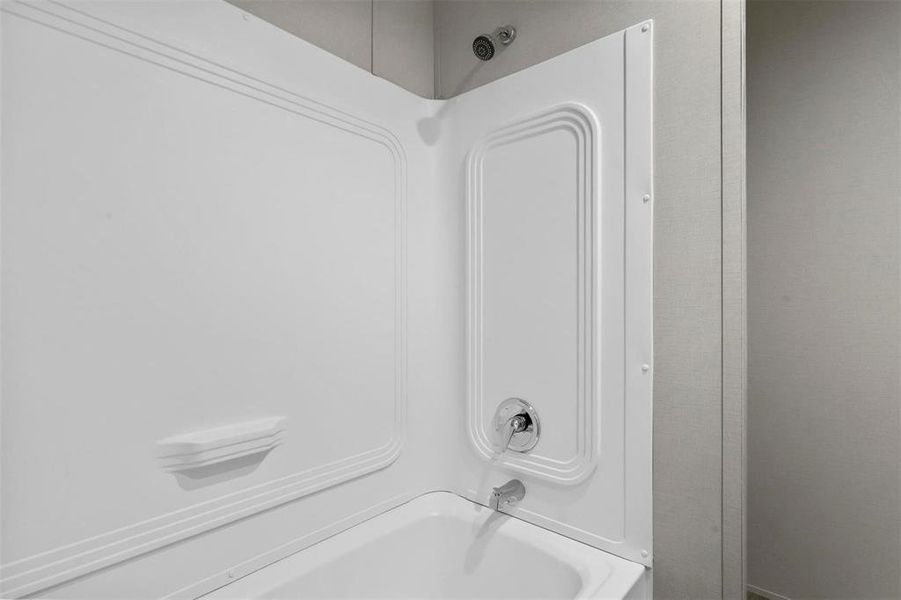 Room details featuring shower / washtub combination