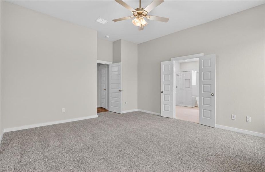 Spacious room featuring vaulted ceilings, light gray wall paint, and gray carpeting Spacious room featuring vaulted ceilings, light gray wall paint, and gray carpeting