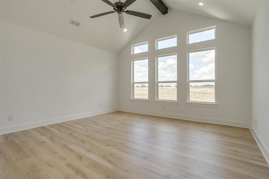 Spare room featuring high vaulted ceiling, ceiling fan, beamed ceiling, and light hardwood / wood-style flooring