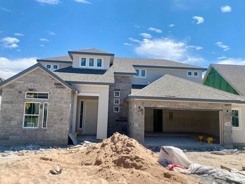 View of front of house with stone siding and an attached garage