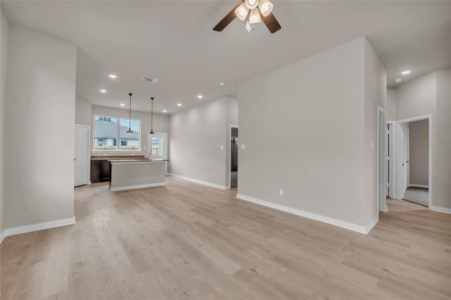 Unfurnished living room featuring a ceiling fan, recessed lighting, and light wood-style flooring