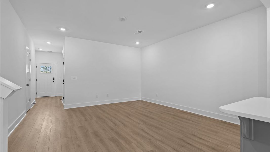 Elegant family room featuring hardwood flooring, large windows, and thoughtful architectural detail