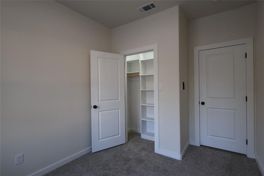 Unfurnished bedroom featuring carpet flooring and a closet