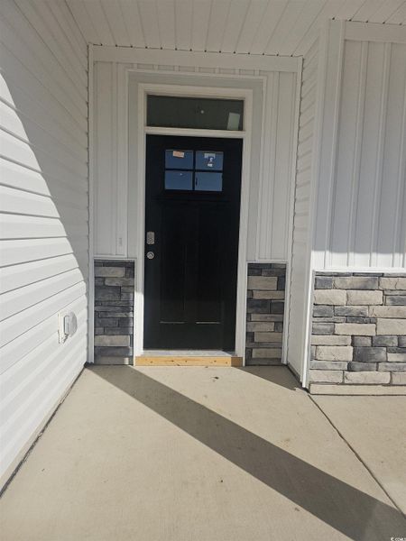 View of exterior entry with board and batten siding