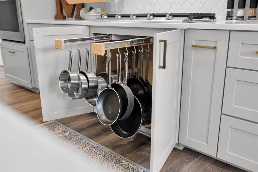 Interior details with decorative backsplash, white cabinetry, and dark wood-type flooring