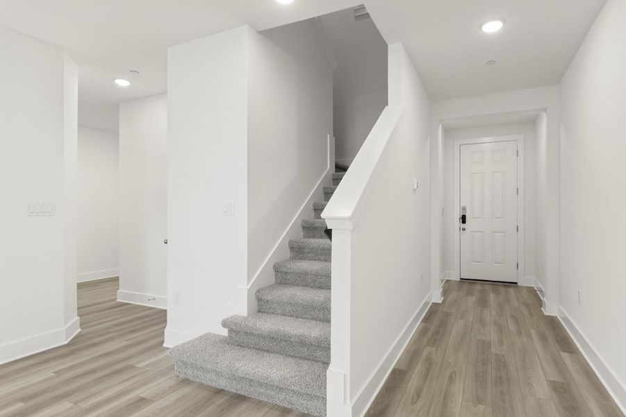 Staircase featuring wood finished floors and recessed lighting