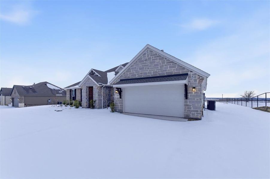 View of front of house featuring stone siding and a garage View of front of house featuring stone siding and a garage