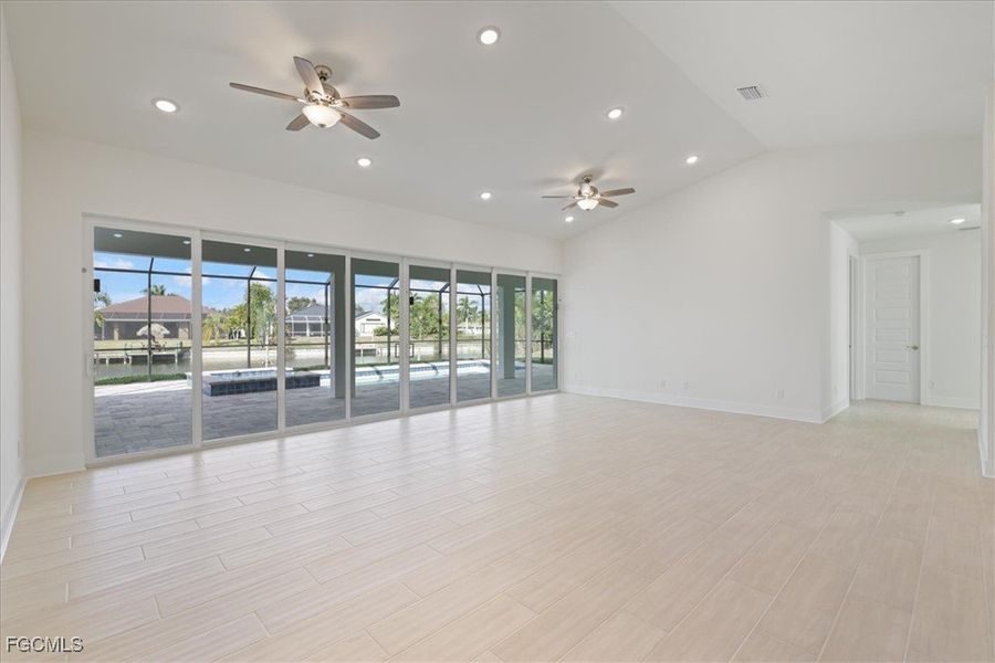 Living room featuring 24 foot slider, recessed lighting, wood finish floors, lofted ceiling, and a ceiling fan