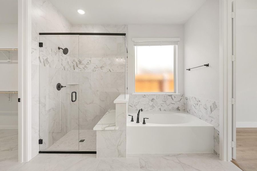 Bathroom with marble tile walk-in glass shower and soaking tub with black fixtures Bathroom with marble tile walk-in glass shower and soaking tub with black fixtures