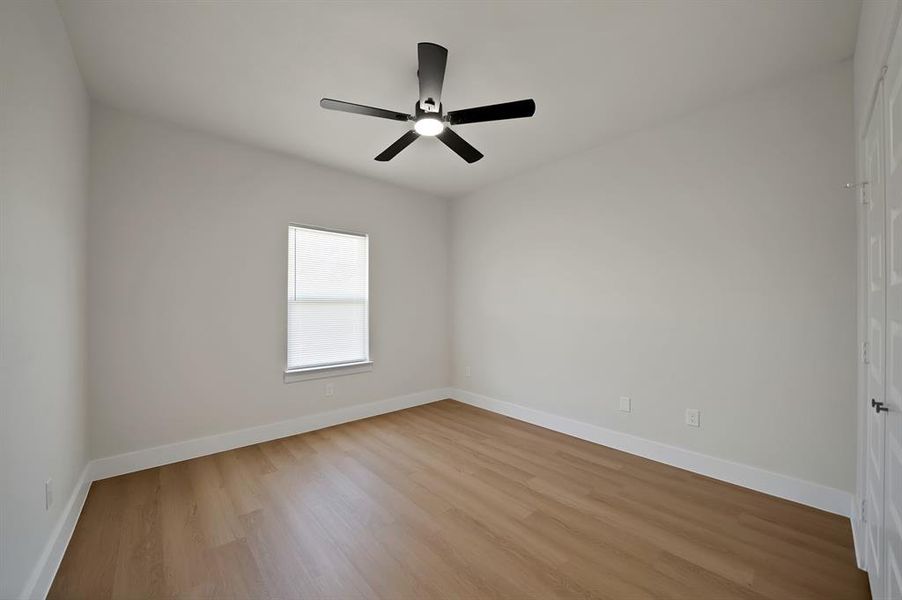 Unfurnished room with light wood-type flooring and a ceiling fan Unfurnished room with light wood-type flooring and a ceiling fan