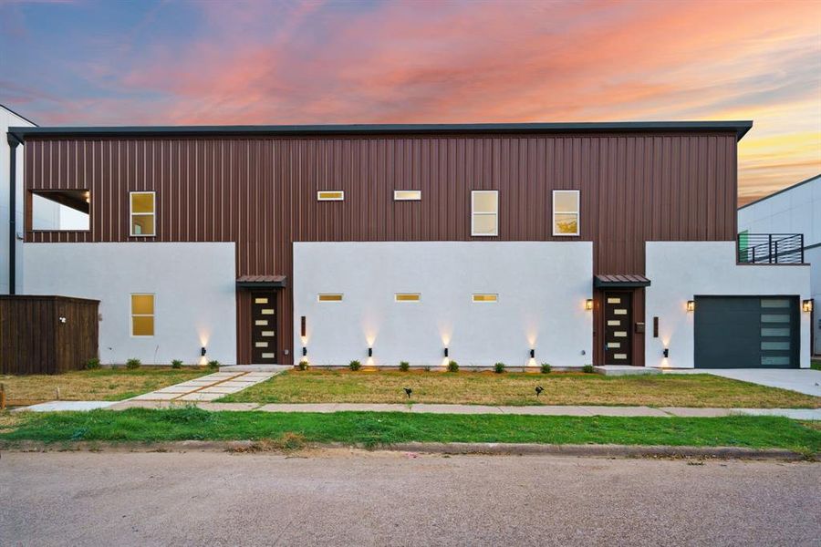 View of front of property featuring board and batten siding, driveway, and a metal roof