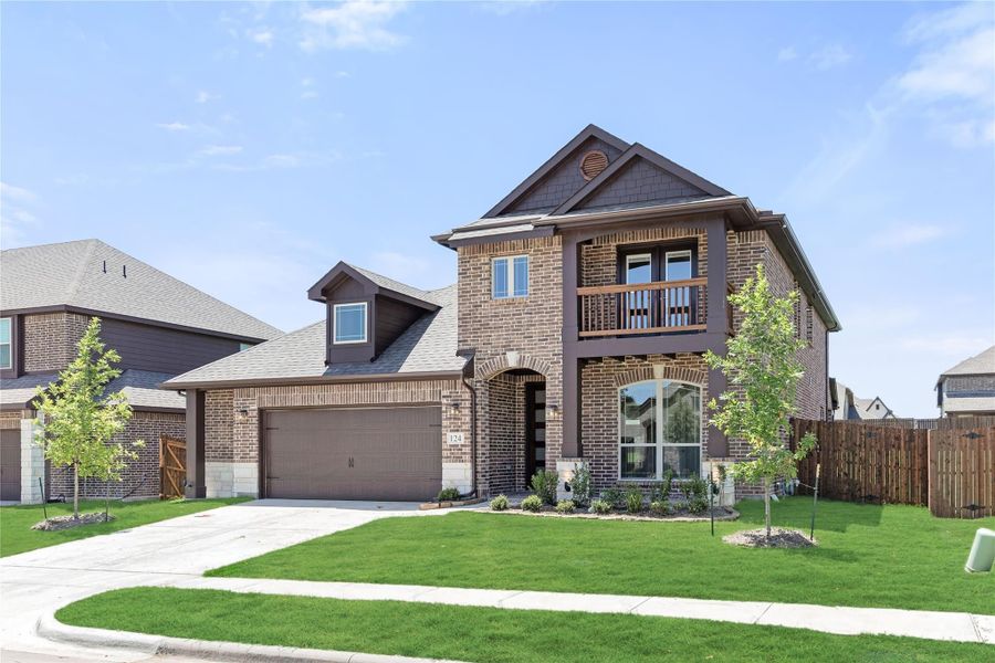 Two-story brick home with two-car garage, second-floor balcony, and manicured front lawn