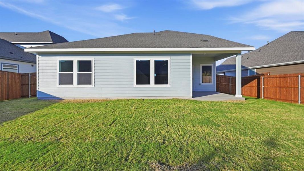 Rear view of house with a patio, a shingled roof, and a fenced backyard Rear view of house with a patio, a shingled roof, and a fenced backyard