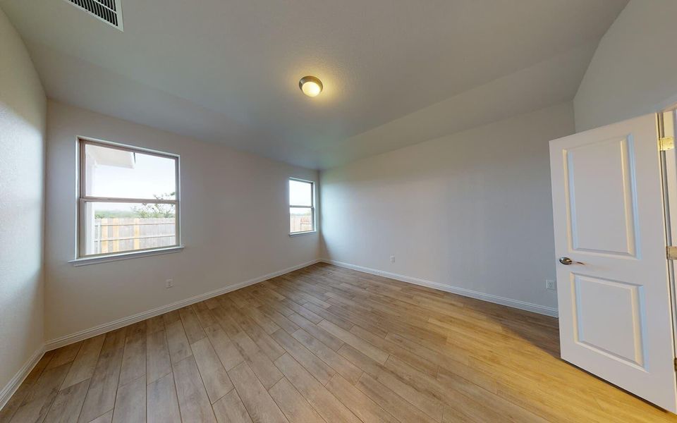 Unfurnished room with lofted ceiling and light wood-style flooring