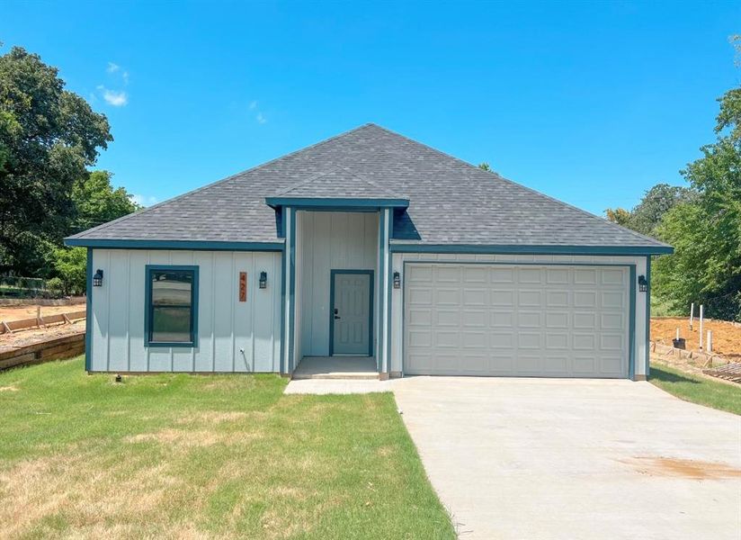 View of front of house with a garage and a front yard