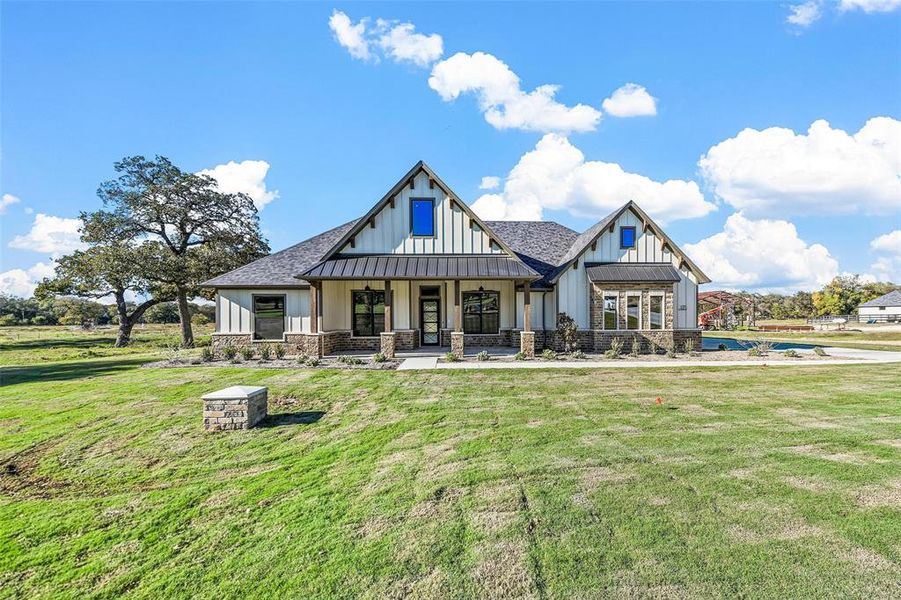 Back of property with a yard and a porch