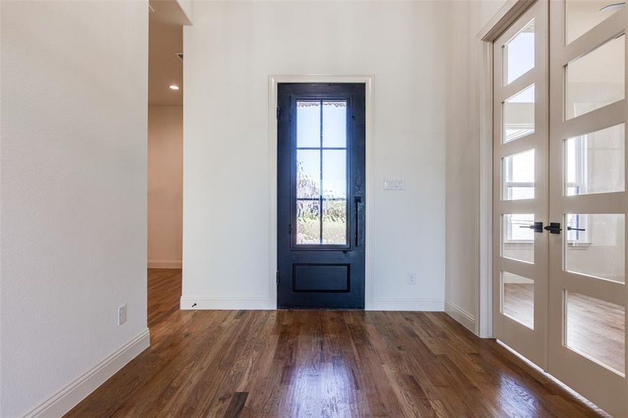 Doorway to outside with french doors and dark wood-type flooring