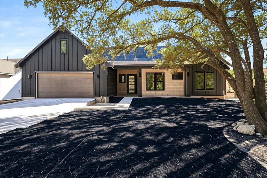 View of front of property featuring board and batten siding, concrete driveway, and an attached garage