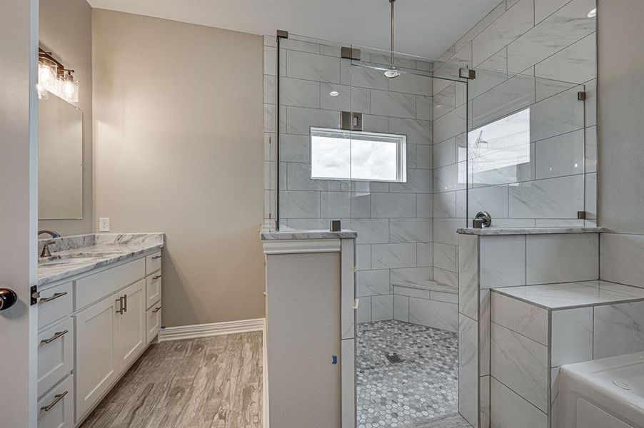 Bathroom with vanity, wood-type flooring, and tiled shower