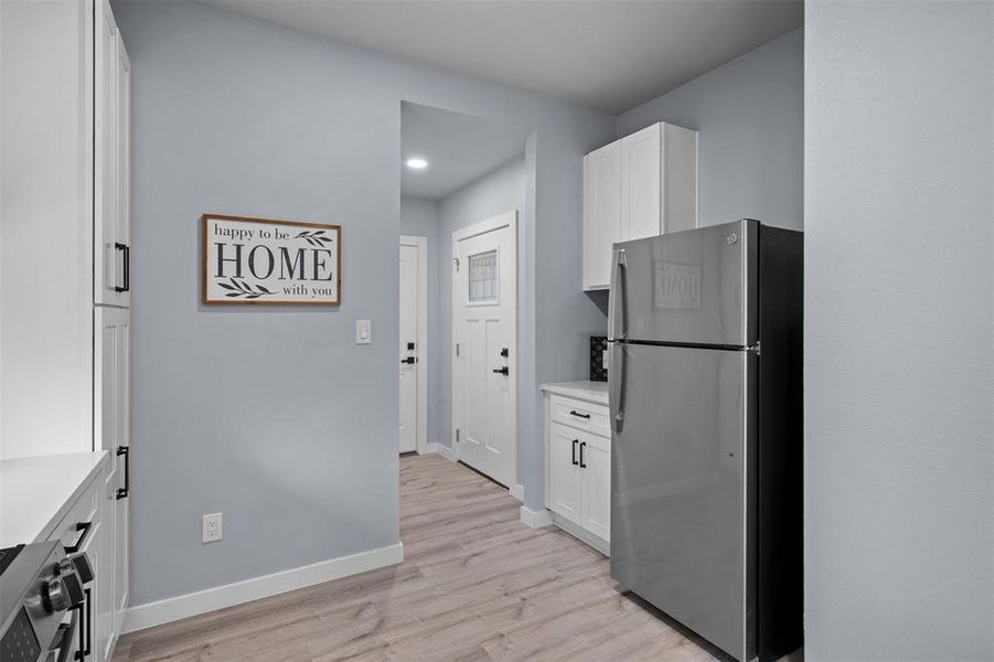 Kitchen featuring white cabinetry, stainless steel appliances, and light countertops Kitchen featuring white cabinetry, stainless steel appliances, and light countertops