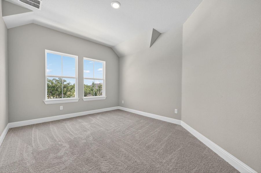 Unfurnished room with lofted ceiling and light colored carpet