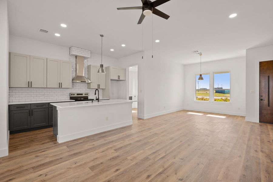 A well-lit, open-concept living area boasts a contemporary kitchen island and elegant wood flooring. A well-lit, open-concept living area boasts a contemporary kitchen island and elegant wood flooring.