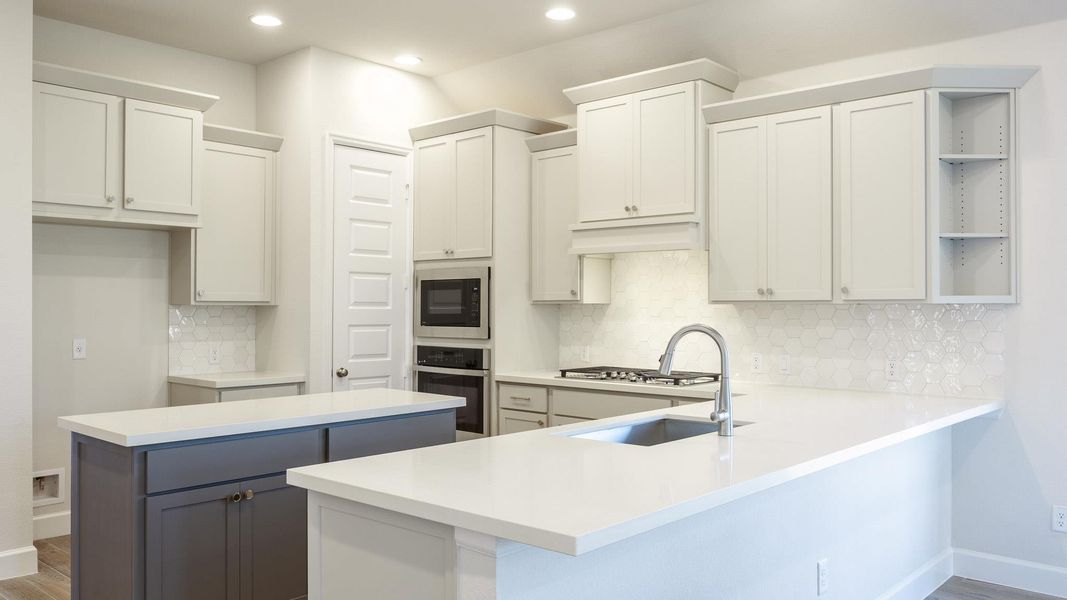 Kitchen featuring open shelves, wood finished floors, stainless steel oven, recessed lighting, and a peninsula Kitchen featuring open shelves, wood finished floors, stainless steel oven, recessed lighting, and a peninsula