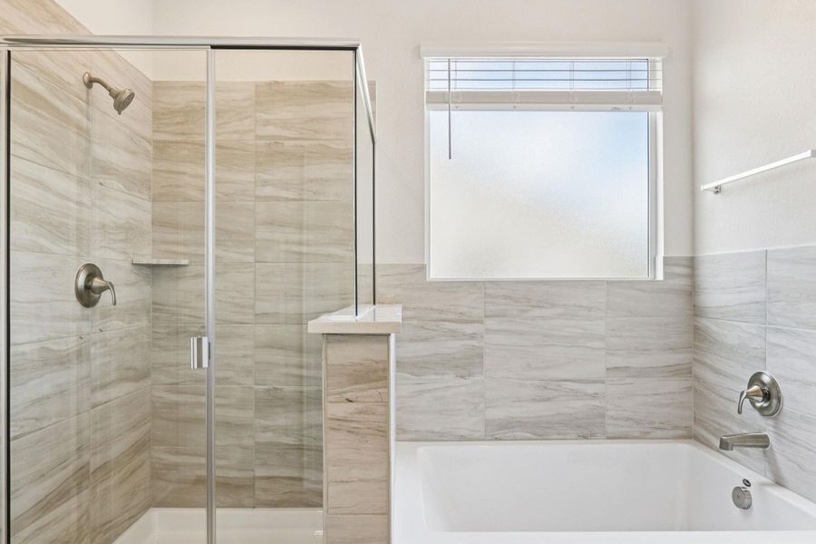 Full bath with a shower stall, a bath, and healthy amount of natural light Full bath with a shower stall, a bath, and healthy amount of natural light