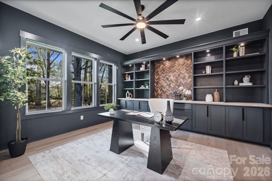 Dedicated office with chevron accent wall, French doors, and built-ins