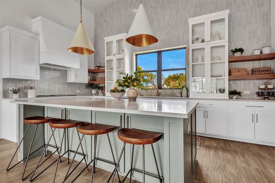 Kitchen featuring open shelves, white cabinets, backsplash, and hanging light fixtures Kitchen featuring open shelves, white cabinets, backsplash, and hanging light fixtures