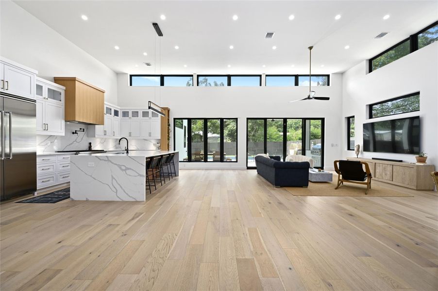 Kitchen with visible vents, a spacious island, light wood-type flooring, built in refrigerator, and open floor plan