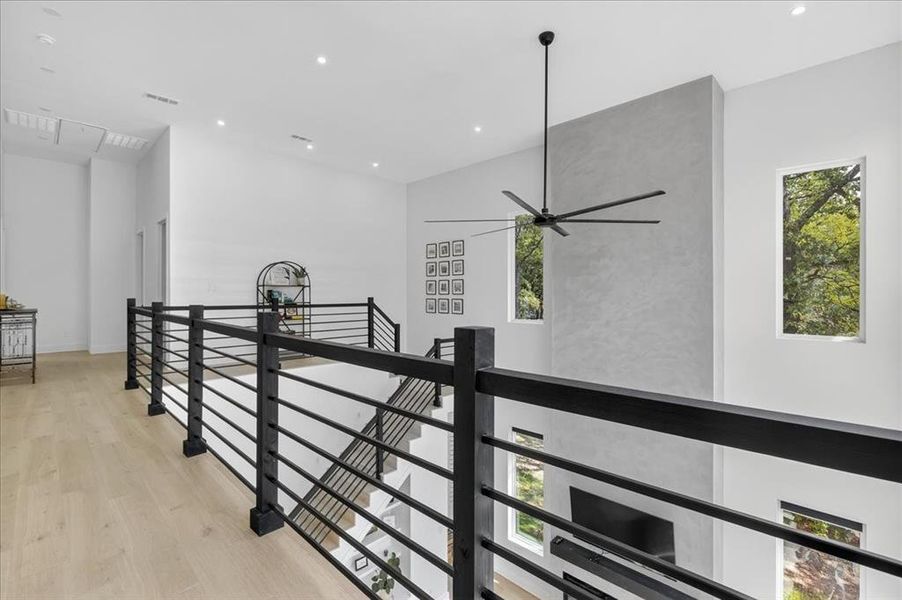 Expansive second-floor catwalk enhances the home's open-concept design. The plaster finish on the fireplace is lovely!
