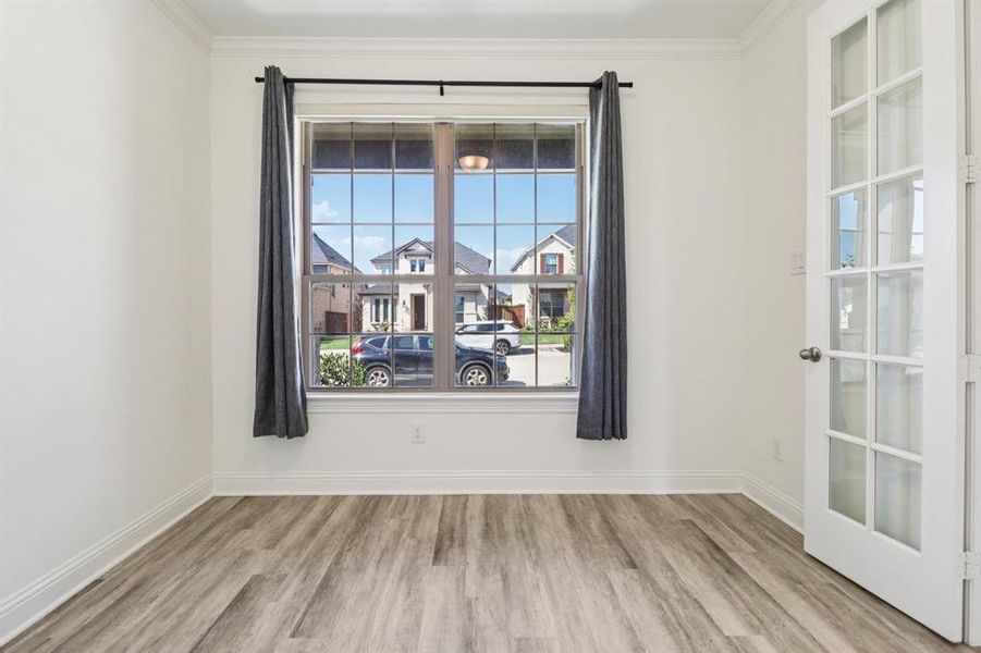 Unfurnished room featuring light wood-type flooring and ornamental molding Unfurnished room featuring light wood-type flooring and ornamental molding