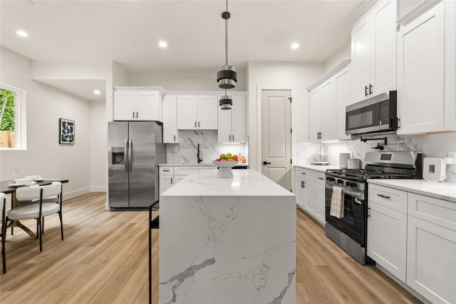 Seamless layout with gas range on one side and full-depth fridge on the other Seamless layout with gas range on one side and full-depth fridge on the other
