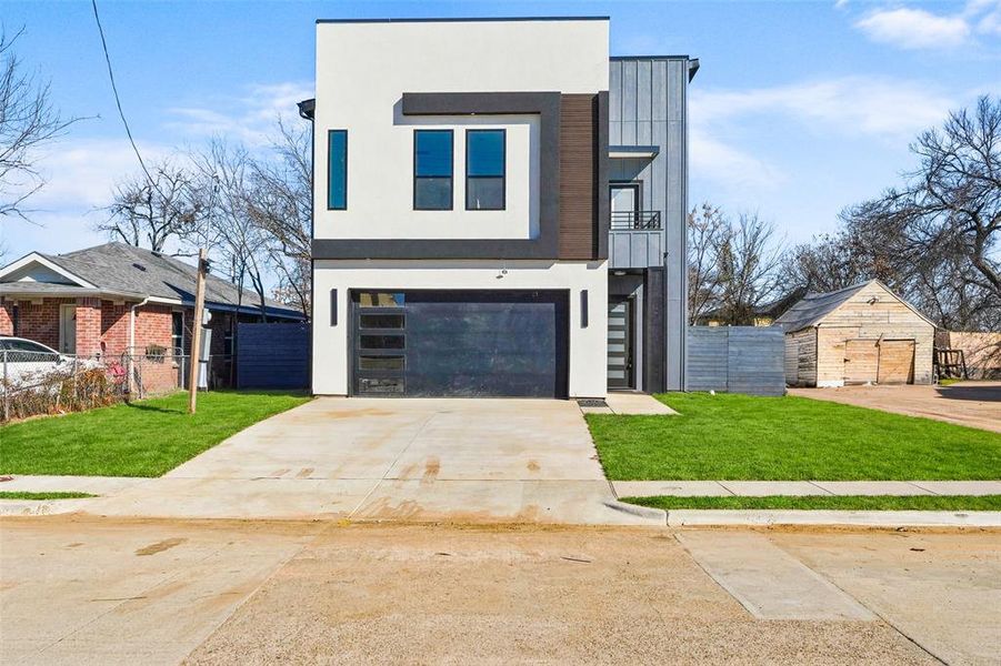 Contemporary house with stucco siding, a garage, concrete driveway, and a balcony Contemporary house with stucco siding, a garage, concrete driveway, and a balcony