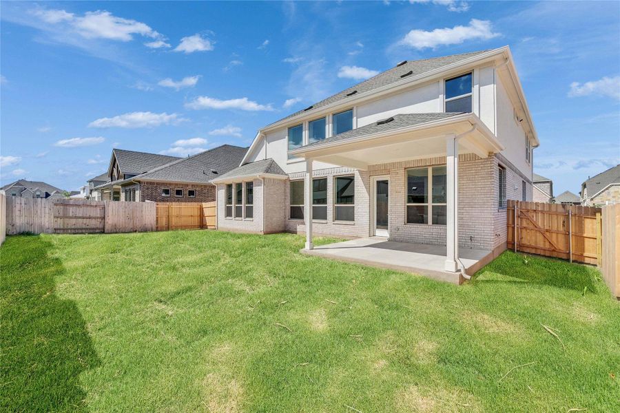 Back of property with a patio, a fenced backyard, and brick siding Back of property with a patio, a fenced backyard, and brick siding