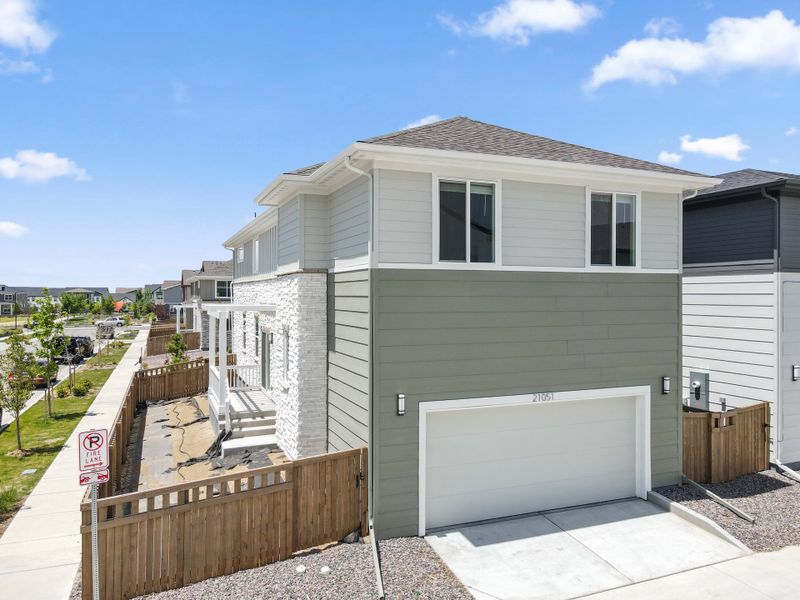 Front exterior of a new home in Woodrose at Painted Prairie, Aurora, CO, highlighting curb appeal (Image 14).