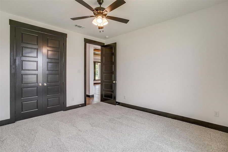 Unfurnished bedroom with a closet, ceiling fan, and carpet floors