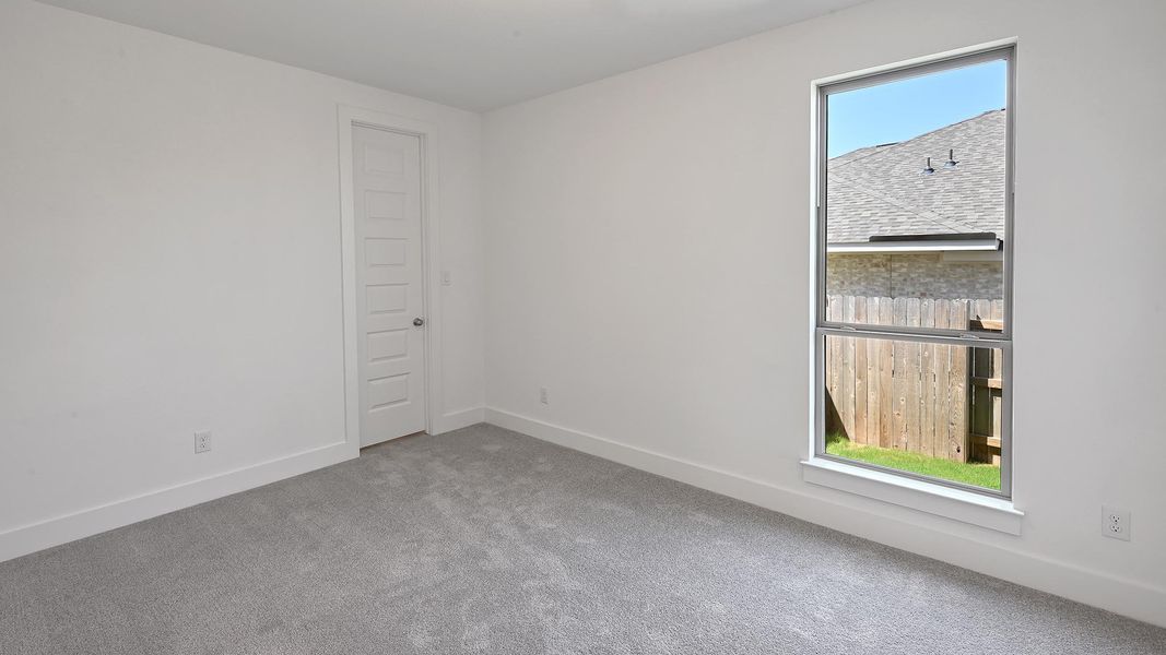 Spare room with carpet and baseboards