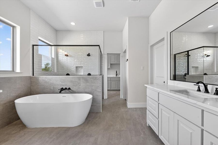 Bathroom with vanity, tile walls, a shower stall, and a soaking tub