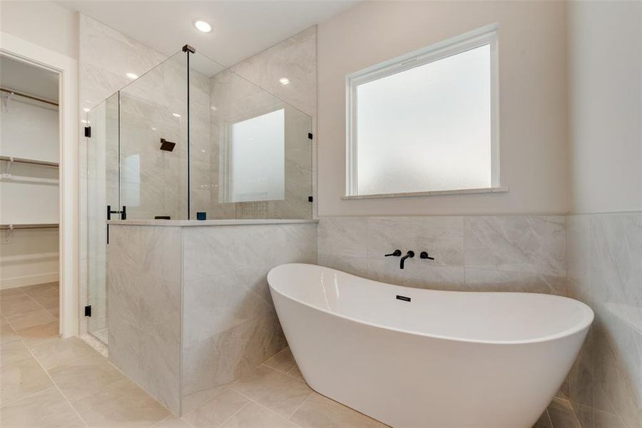 Bathroom featuring tile walls, tile flooring, and independent shower and bath