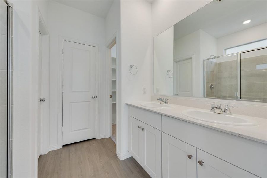 Bathroom with vanity, wood-type flooring, and an enclosed shower